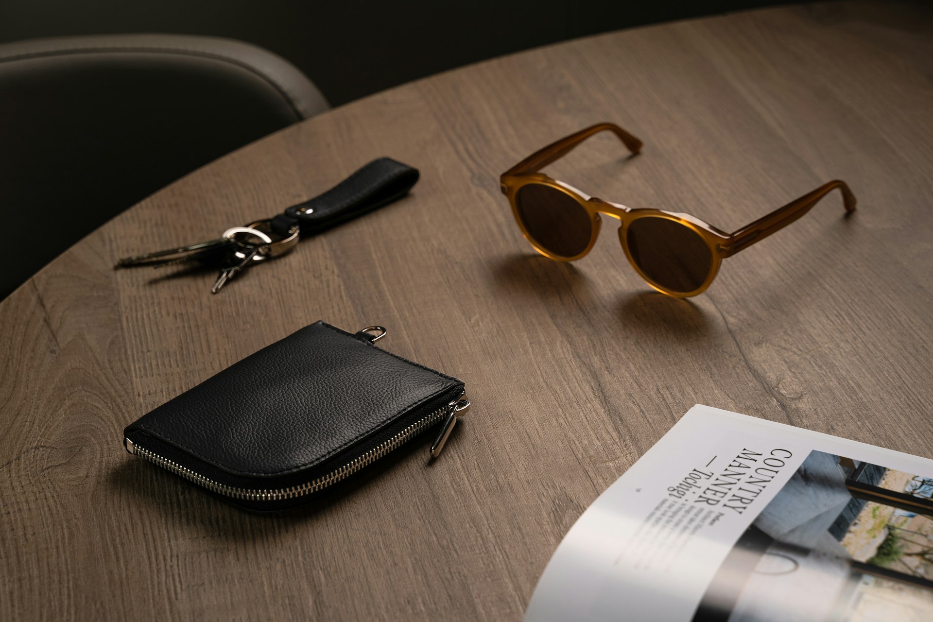 Black leather zip wallet with sunglasses and keys