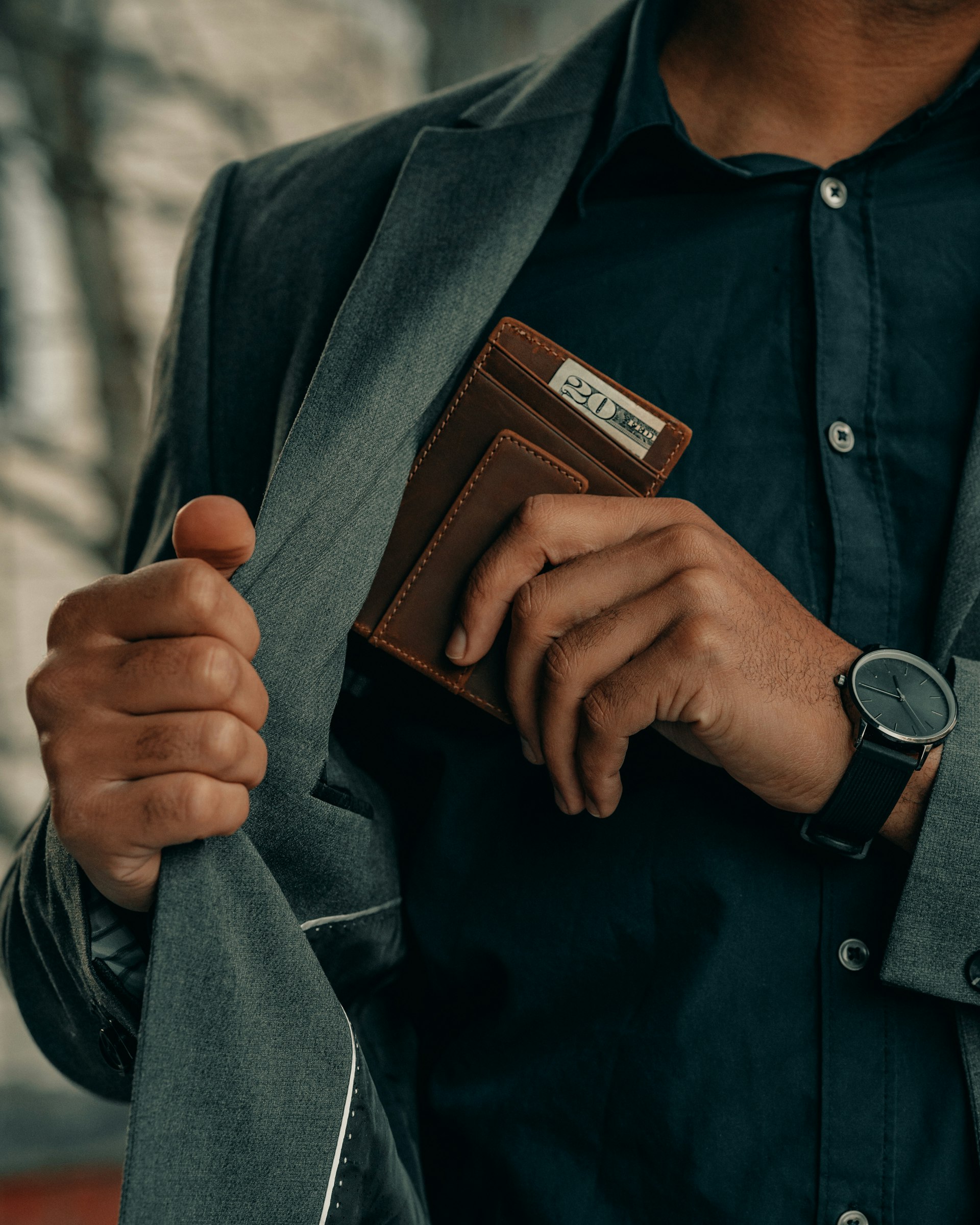 Man holding a brown leather wallet