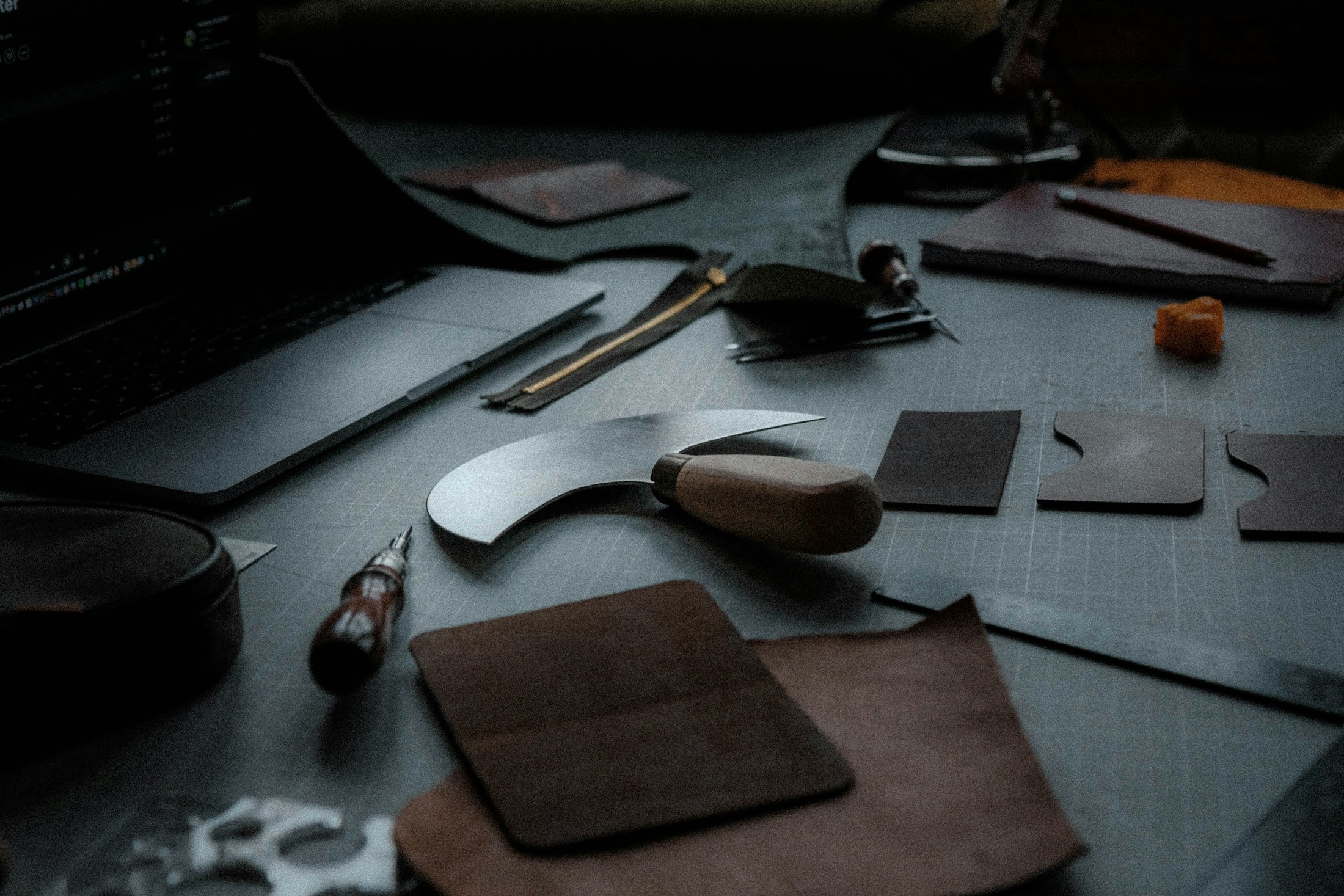Leatherworking tools on a dark workbench